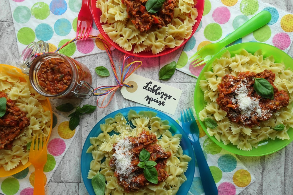 Nudeln/Pasta mit Fleischsoße für Kinder; bunte Teller und Servietten