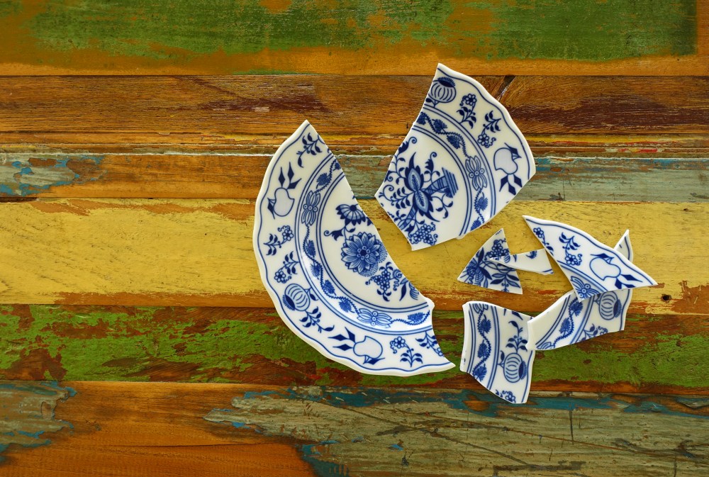 zerbrochener Teller auf hölzernem Untergrund