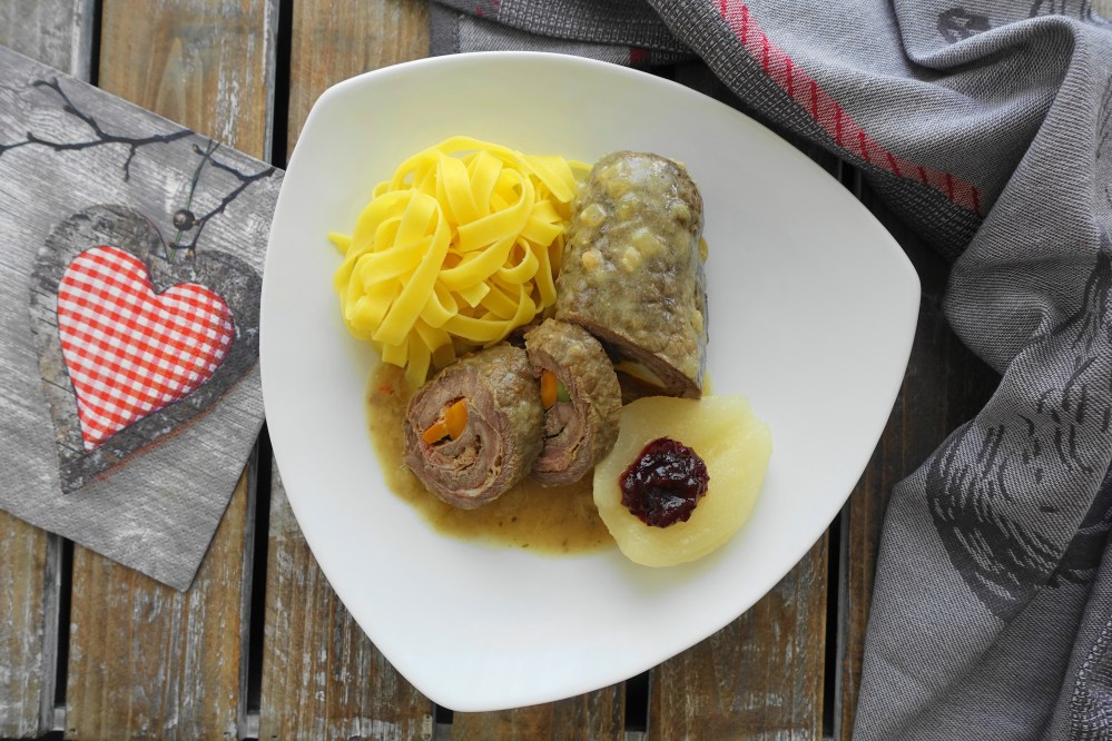 Rindsroulade in Zwiebelsoße und Bandnudeln; dazu eine halbe Birne mit Preiselbeermarmelade;