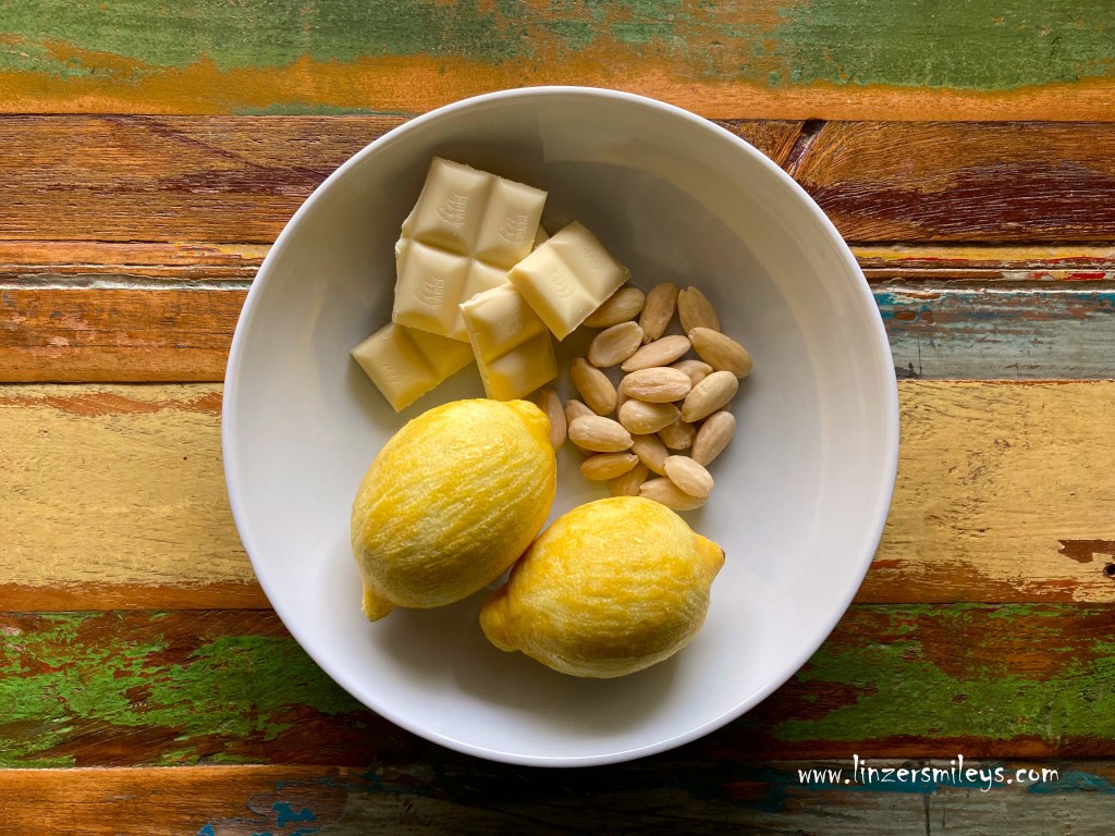 Zutaten für eine Torta caprese al limone e cioccolato bianco, mit Zitrone und weißer Schokolade, blanchierte Mandeln
